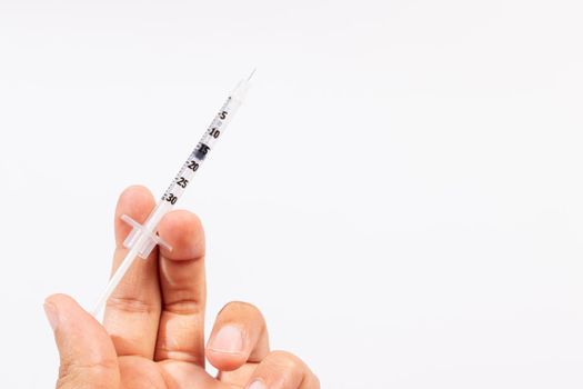 Hand holding an insulin syringe before being used