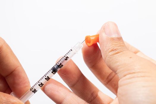 Hand holding an insulin syringe before being used