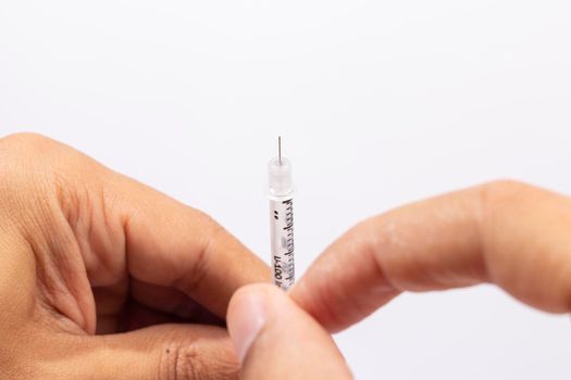 Hand holding an insulin syringe before being used