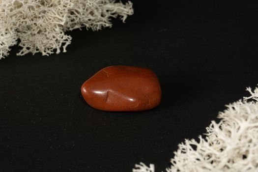 Red Jasper from Brazil. Natural mineral stone on black background. Mineralogy, geology, magic of stones, semi-precious stones and samples of minerals. Close-up macro photo.