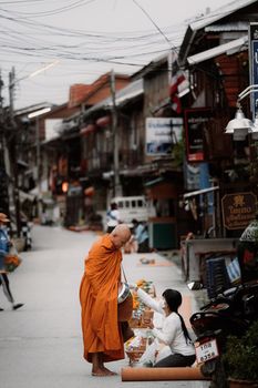 CHIANG KHAN , LOEI, Thailand - 21 OCT, 2020 : Thai monks go with a bowl to receive food or Sticky rice from tourist in early morning at ChiangKhan Walking street, Loei Province, Thailand.