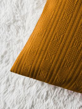 Golden cushion throw pillow on white fluffy plaid blanket as flat lay background, bedroom top view and home decor flatlay