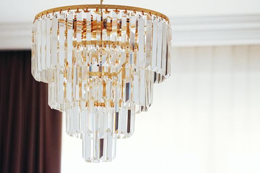 Crystal glass chandelier with golden details, luxury furniture and home decor concept