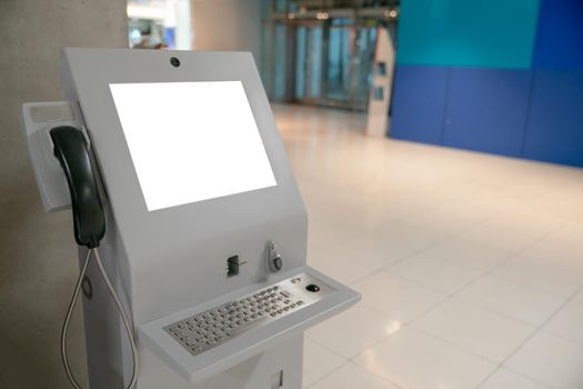 Automated information machine with mock up white screen in airport.