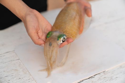 Preparation of raw squid on cutting board.