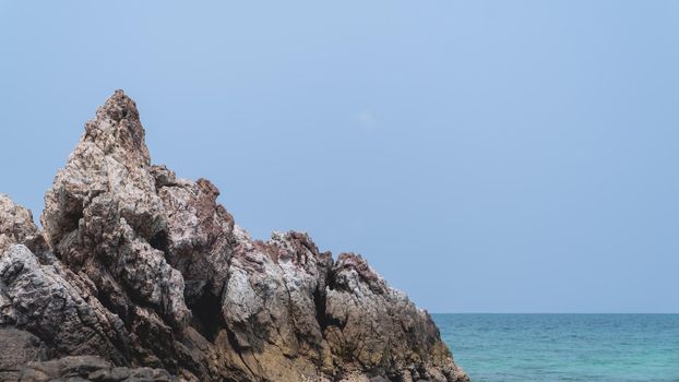 Tropical beach, rock and sand background with blue sky.