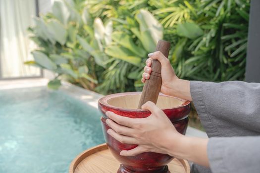 Woman hand making thai food call papaya salad or Som Tam, mixing and pounding in a mortar.