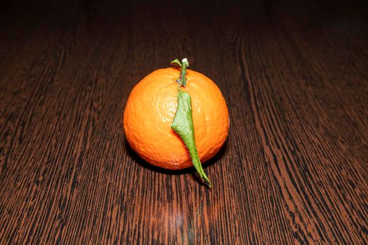tangerine with leaves on a wooden table. High quality photo