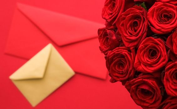 Holiday gift, flowers flatlay and happy relationship concept - Love letter and flower delivery service on Valentines Day, luxury bouquet of red roses and card envelopes on red background