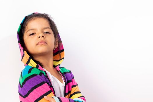 Little girl with cute face with her colorful sweater, with a white background