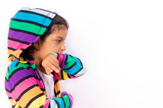 Little girl with cute face with her colorful sweater, with a white background