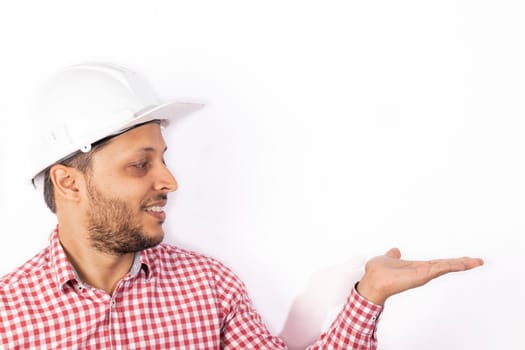 Handsome builder worker with white helmet showing his hands