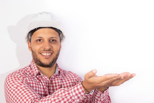 Handsome builder worker with white helmet showing his hands