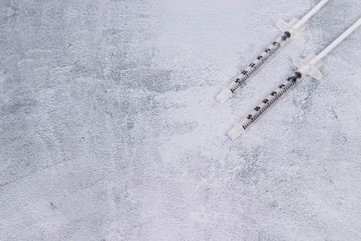 Two syringes on a gray marbled background