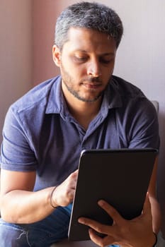 Handsome man working at home with his tablet