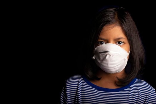 Portrait of little girl wearing a medical mask used for virus protection