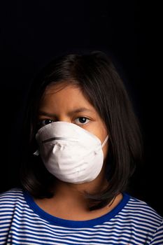 Portrait of little girl wearing a medical mask used for virus protection