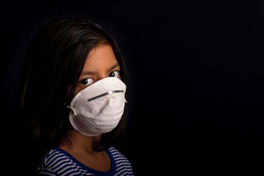 Portrait of little girl wearing a medical mask used for virus protection