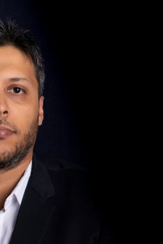 Half face portrait of handsome man smiling with little beard and with black background