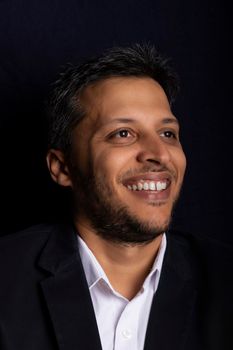 Portrait of handsome man smiling with little beard and with black background