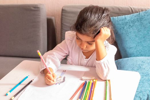 Girl is drawing and painting at a small table