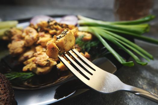 A slice of fried chicken at the end of a fork