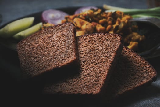 Chicken dish, black bread, onions and cucumbers