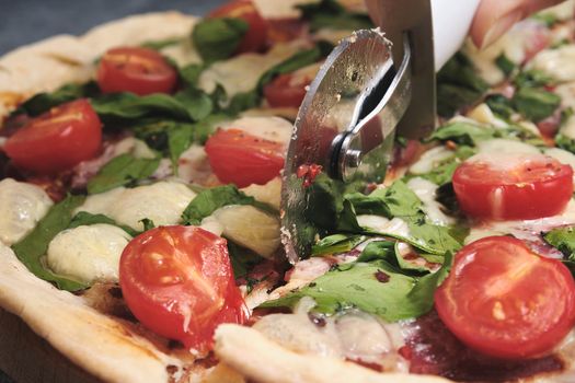 Pizza with cheese, tomatoes, spinach and smoked sausage