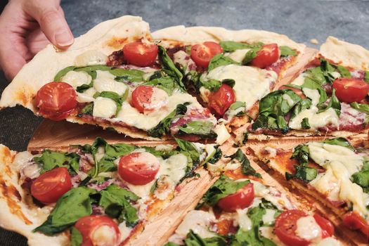 Pizza with cheese, tomatoes, spinach and smoked sausage