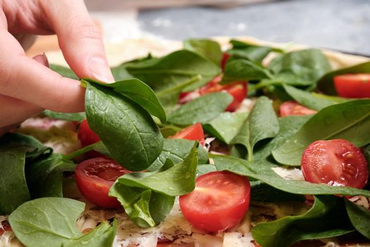 Pizza with cheese, tomatoes, spinach and smoked sausage