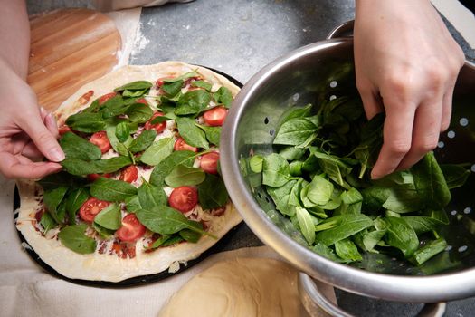 Pizza with cheese, tomatoes, spinach and smoked sausage
