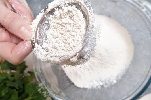 Flour is sieved with a metal sieve