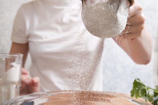 Flour is sieved with a metal sieve