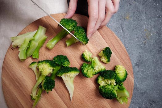 Chopping broccoli on a cutting board.