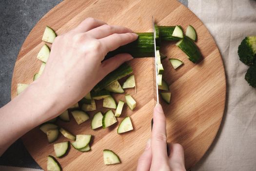 Chopping a cucumber on a cutting board