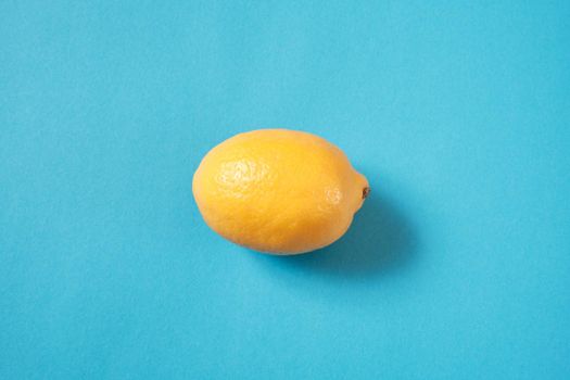 Fresh lemon lies on a blue textured background