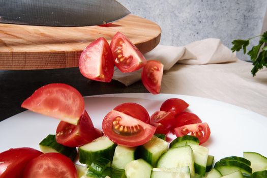 Cut tomatoes fall on a plate