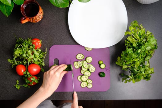 Slicing cucumbers with a knife on a cutting board