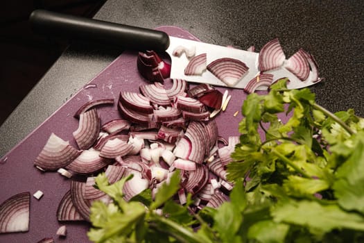 Slicing onions with a knife on a cutting board