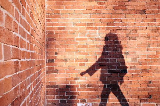 Shadow of a man on a brick wall background