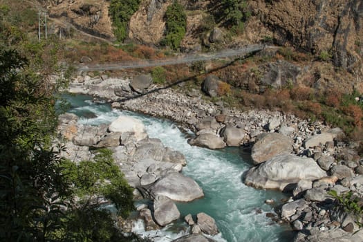 Trekking Nepal, suspention bridge over beautiful Marshyangdi river, Annapurna circuit