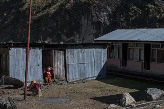 Nepalese woman sitting resting at her house along Annapurna trek circuit