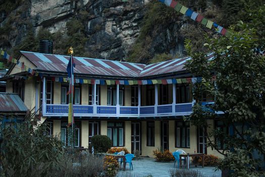 Colorful tea house lodge with prayer flags in Dharapani, Marshyangdi river valley gorge, Annapurna circuit, Himalaya, Nepal, Asia