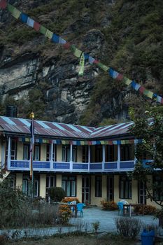 Colorful tea house lodge with prayer flags in Dharapani, Marshyangdi river valley gorge, Annapurna circuit, Himalaya, Nepal, Asia