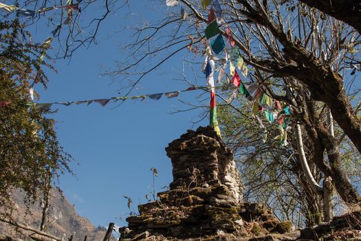 Colorful buddhist prayer flags hanging, blowing in the wind by the mountains