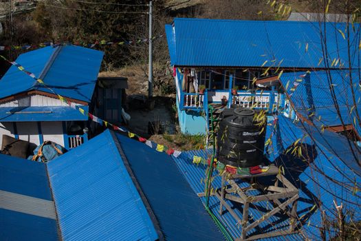 Blue tea houses with buddhist prayer flags in nepalese mountain village