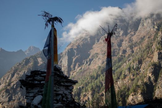 Colorful buddhist prayer flags hanging, blowing in the wind by the mountains