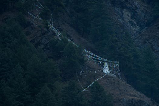 Buddhist stupa and prayer flags on the mountain side in Chame, Annapurna circuit, Himalaya, Nepal, Asia