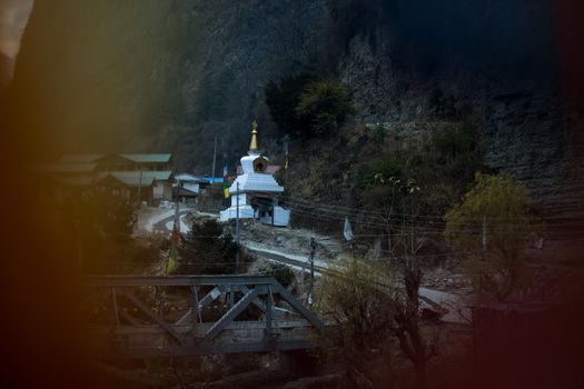 Buddhist stupa seen through prayer flags in Chame mountain village, trekking Annapurna circuit, Nepal
