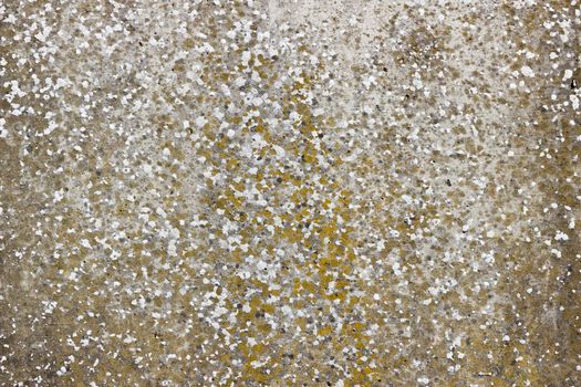 A flat grey concrete surface. The surface is textured and covered in holes from lots of tiny air bubbles.